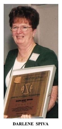 A woman holding a plaque in front of her face.