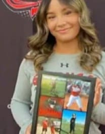 A girl holding up a picture of herself.