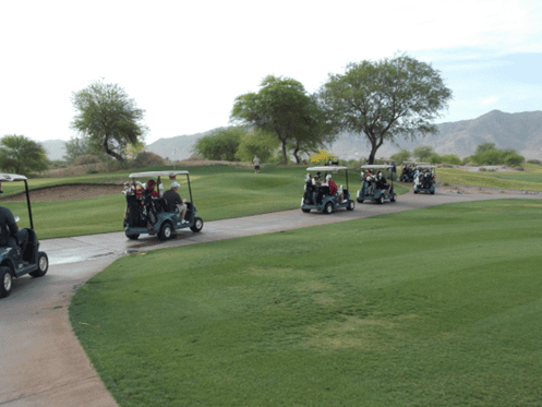 A group of people riding carts down the road.